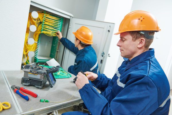 internet connection. technician engineer working with arc fusion splice machine while connecting fiber optic cable.